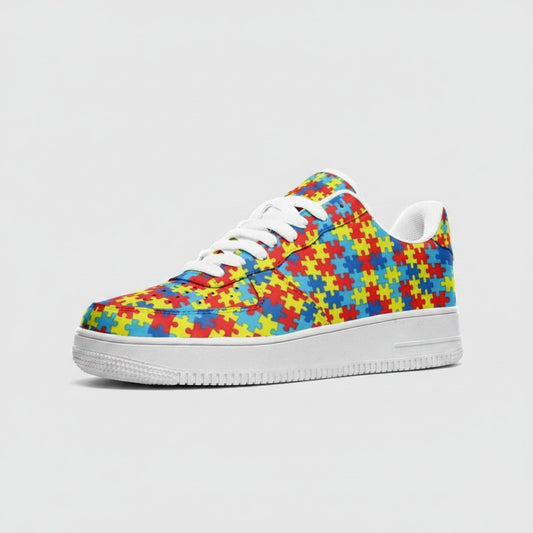 Freaky Shoes® low-top leather sneakers featuring a colorful autism puzzle piece print and white rubber outsole.