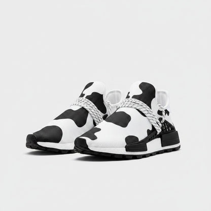 Freaky Shoes® high-top canvas sneakers featuring a black and white cow print pattern with lace-up closure.