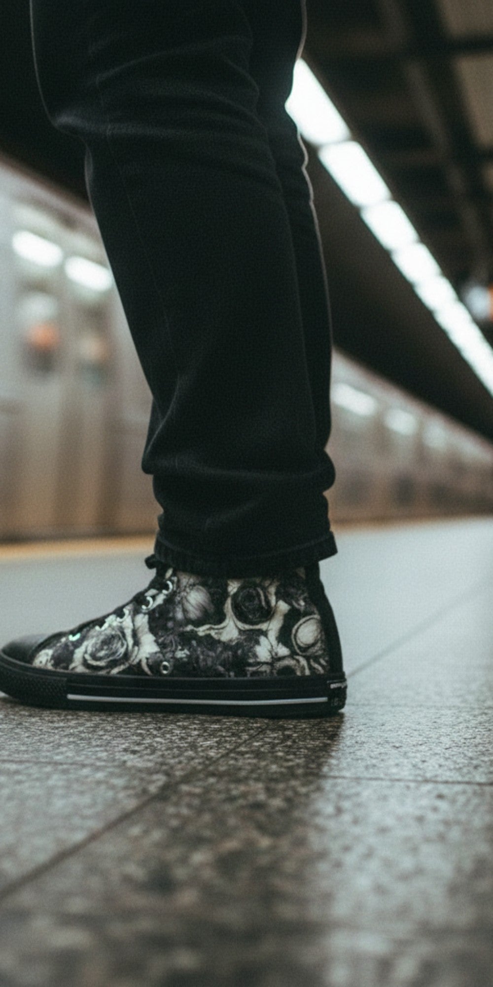 Freaky Shoes® Gothic skull and rose print high top canvas sneakers worn on a subway platform.