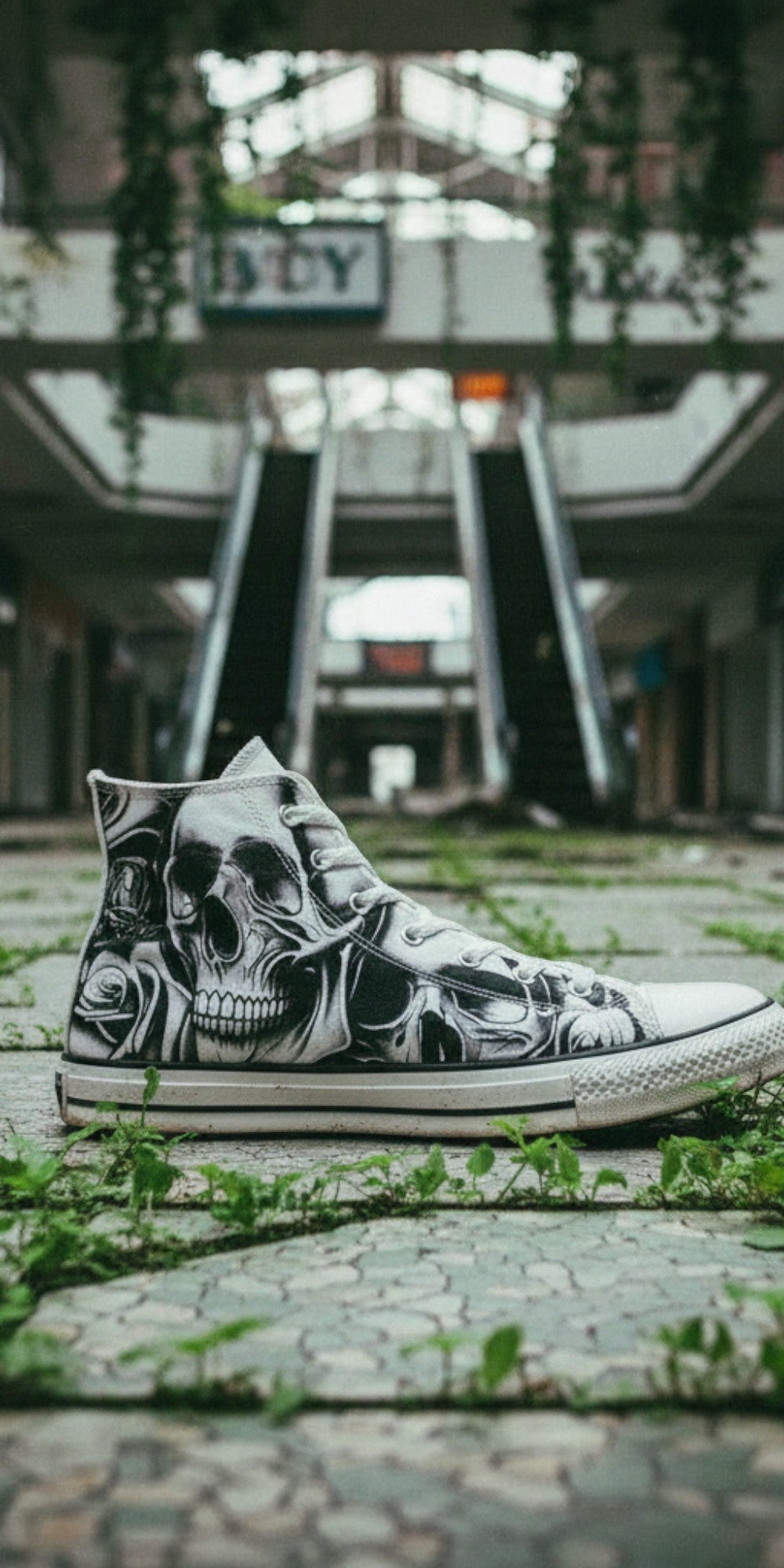 Freaky Shoes® high-top canvas sneakers featuring a grey skull and rose print, set in an abandoned indoor mall.