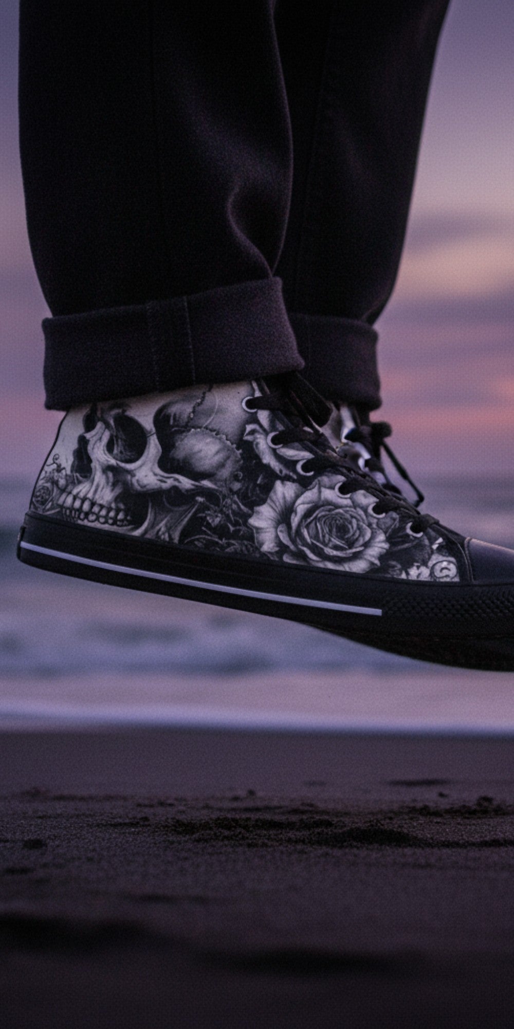 Freaky Shoes® men's high top canvas sneakers featuring a black and white skull and rose dark art print on a beach.